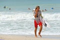 Surfer Carry Surfboard onto the Beach