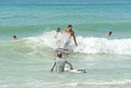 Surfers on the Beach Riding a Wave