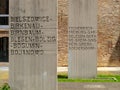 The Holocaust memorial with written stele and green grass and roses