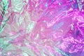 Holographic background in the style of the 80-90s. Real texture of cellophane film in bright acid colors. Royalty Free Stock Photo