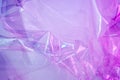 Holographic background in the style of the 80-90s. Real texture of cellophane film in bright acid colors. Royalty Free Stock Photo