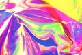 Holographic iridescent surface. Copy space. Bright colorful hologram background. Wrinkled abstract texture with multiple colors.