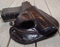 A holstered black pistol on a wooden table