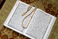 Holy Al Quran and prayer beads on the prayer mat
