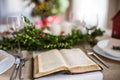 Holy bible book on a table set for a dinner at home at Christmas time. Royalty Free Stock Photo