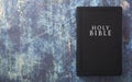 A Holy Bible Closed on a Blue Wooden Table with Copy Space Royalty Free Stock Photo