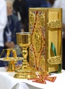Holy Bible in golden cover, golden cup and candleholder, church service