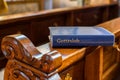 Holy Bible lying on a bench in church