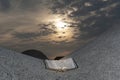 The Holy Bible open outdoors on top of a rock under the orange light of the sun at dawn Royalty Free Stock Photo