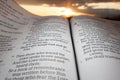 Holy Bible open at sunset with highlight on Malachi chapter 4 verse 2. Background with sun and clouds Royalty Free Stock Photo