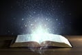 Holy Bible open with glowing lights Royalty Free Stock Photo