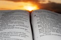 Holy Bible opened at sunset, highlighted in Malachi chapter 4 verse 2. Background with sun rays and clouds Royalty Free Stock Photo