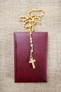 Holy Bible and rosary on jute background Royalty Free Stock Photo