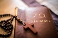 Holy bible and rosary: Christian bible and rosary on a wooden desk Royalty Free Stock Photo