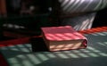 Holy bible on top of red wood and green leather table