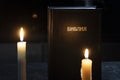 Holy Bible and two burning candles on the white table. concept of faith and religion. christian faith. The inscription on the book Royalty Free Stock Photo