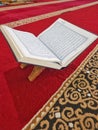 The holy book Al Qur& x27;an isolated on the wood and red carpet of an Indonesian mosque. Royalty Free Stock Photo