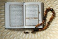 Holy book for muslims,Koran and rosary on wooden engraving background.