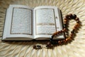 Holy book for muslims,Koran and rosary on wooden engraving background.