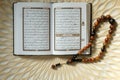 Holy book for muslims,Koran and rosary on wooden engraving background.