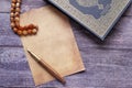 empty paper , Holy book Quran and rosary on table, close up. Royalty Free Stock Photo