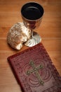 Holy Communion and Easter concept with The Holy Bible. bread and a silver chalice of red wine