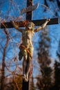 Holy cross with crucified Jesus Christ. Very ancient statue in ivy. Vertical image Royalty Free Stock Photo