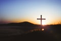 The holy cross of Jesus Christ on the grass with a strong light in the sunset sky Royalty Free Stock Photo