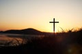 The holy cross of Jesus Christ on the grass with a strong light in the sunset sky Royalty Free Stock Photo