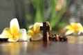 Holy Cross of rosary closeup in low angle view. Wooden rosary with Jesus Christ crucifix and Bali frangipani flowers. Copy space.