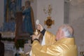 Holy host in the hands of the priest on the altar during the celebration of the mass and empty space for text