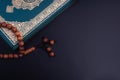Holy Quran with arabic calligraphies translation meaning of Al-Quran and Rosary or Tasbih on black background