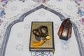 Holy Quran book, rosary and arabian lantern on praying mat