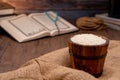 Holy Quran and a grain of rice in a wooden bowl in the sack on a wooden table, Islamic zakat concept.