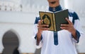 Holy Quran in Hand. Muslim man holding Quran