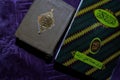 A Holy Quran and Prayer beads on the purple Prayer rug. Eid mubarak or islamic concept