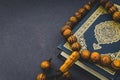 Holy Quran with tasbih or rosary beads over black background
