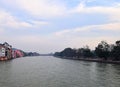 The Holy River Ganges - Ganga with both Banks, Buildings and White Clouds in Blue Sky - Haridwar, Uttarakhand, India Royalty Free Stock Photo