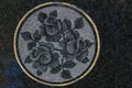 Holy rose symbol with circular gold plastered background on black and white stone background.