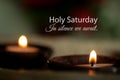 Holy Saturday concept with candle light in a traditional ceramic bowl and text quote - In silence we await. Happy Holy Saturday.