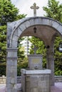 A holy spring of water surrounded by a stone with a cross and a stone awning. Montenegro. Becici Royalty Free Stock Photo