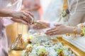 Holy water pouring ceremony over bride and groom hands, Thai traditional wedding engagement