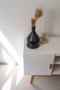 Dark glass bottle, modern decoration, candle holder, candlestick over white console table