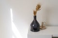 Dark glass bottle, modern decoration, candle holder, candlestick over white table