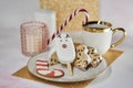 Home aesthetic, cozy tea time. Festive tea cup, Christmas stollen, marshmallow deer, caramel stick, pink candle and
