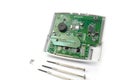 Home alarm control panel repairing. Open Electronic board panel with screwdrivers on a white background. Royalty Free Stock Photo