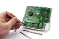 Home alarm control panel repairing. Open Electronic board panel with screwdrivers on a white background. Royalty Free Stock Photo