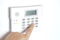 Home Alarm Panel to control security system with a person`s hand Royalty Free Stock Photo