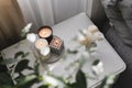 Home aroma fragrance diffuser and burning candles on bedside table in the bedroom. Cozy mood concept