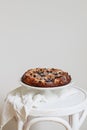 Home baked apple pie with blueberries on top on a white stool Royalty Free Stock Photo